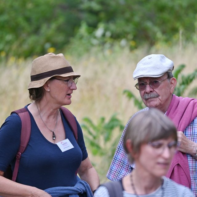 Menschen unterhalten sich bei einem Spaziergang durch die Natur.