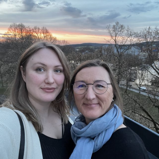 Zwei Frauen machen ein Selfie vor einem Sonnenuntergangpanorama